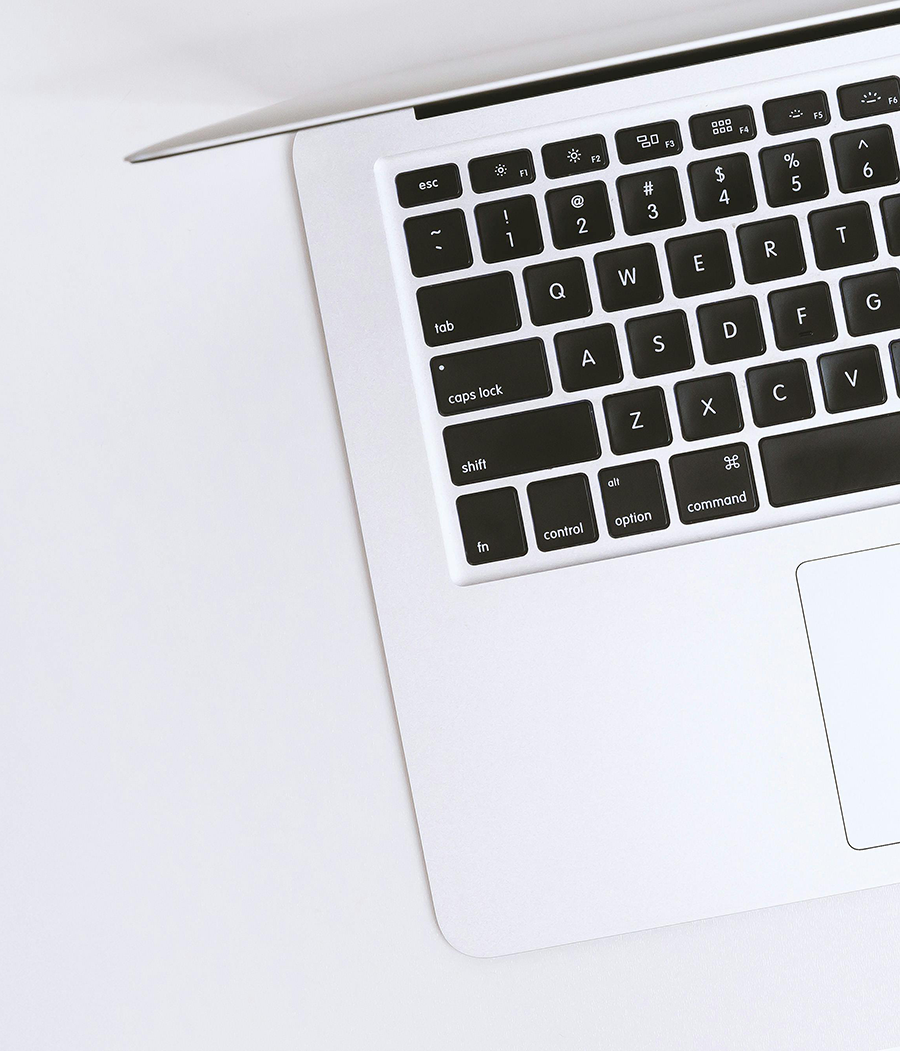 What are domains used for A partial view of a silver laptop keyboard and trackpad on a white surface, photographed from above.