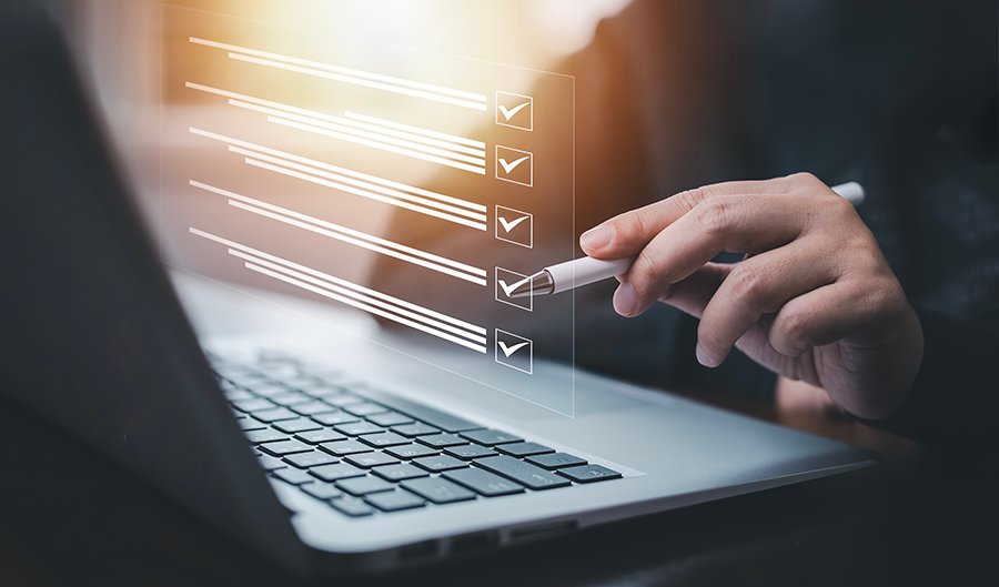 Steps to Register an Internet Domain A hand holding a stylus hovers over a laptop keyboard, interacting with a transparent virtual checklist displayed on the screen.