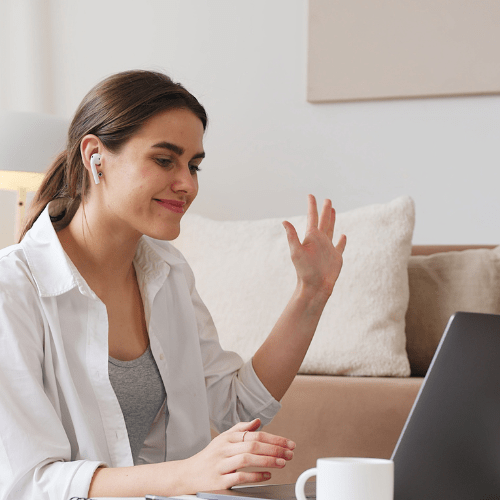 Woman on a virtual call smiling and waving
