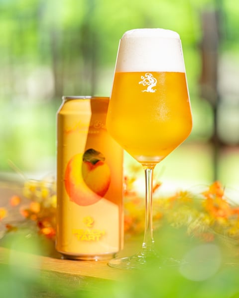 Woodstock Peach Tart is a delicate little beer that bursts with notes of juicy yellow peaches, peach ring gummies, an…