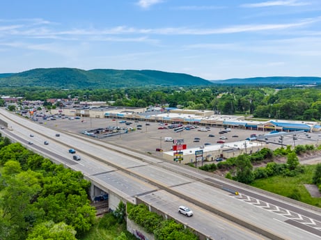 An image featuring cloud, sky, car, infrastructure, vehicle, road surface, mountain, asphalt, tree, thoroughfare at 1040 Center St.