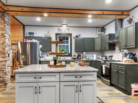 A kitchen at 17899 US-6 featuring: cabinetry, countertop, building, kitchen, kitchen appliance, kitchen stove, wood, drawer, tap, kitchen sink