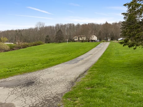 An image featuring cloud, sky, plant, property, natural landscape, tree, land lot, road surface, asphalt, grassland at 1569 S Macafee Rd.