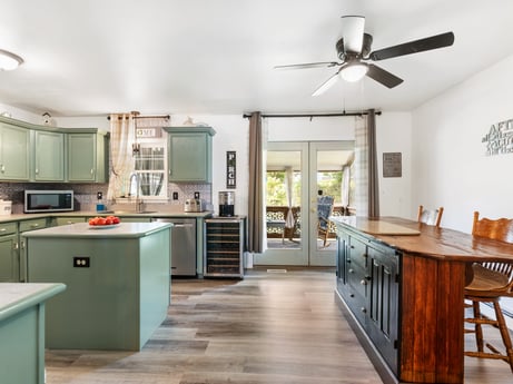 A kitchen at 105 Thomas St featuring: cabinetry, countertop, furniture, ceiling fan, kitchen, lighting, wood, chair, home appliance, floor