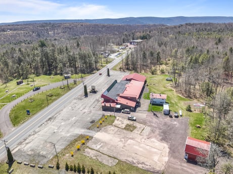 An image featuring sky, plant, cloud, vehicle, slope, truck, car, tree, asphalt, land lot at 4741 US-220.