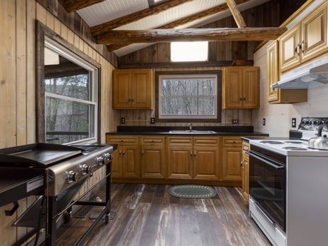 A kitchen at English Hollow Ln featuring: cabinetry, countertop, furniture, window, building, drawer, kitchen, wood, kitchen stove, kitchen appliance