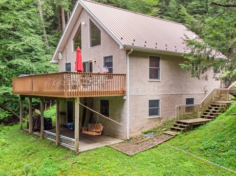 An image featuring window, plant, building, wood, tree, land lot, house, cottage, siding, landscape at 459 Pine Hill Dr.