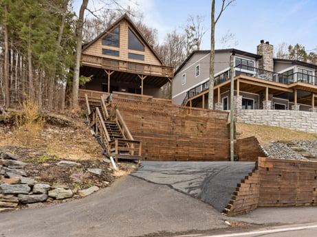 An image featuring sky, building, plant, wood, house, slope, land lot, tree, siding, stairs at 815 Lakeside Dr.