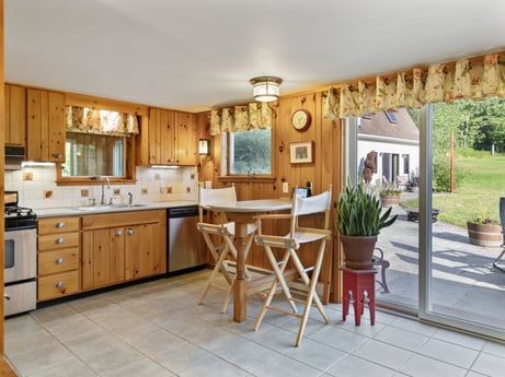 A kitchen at 130 Haighs Pond Rd featuring: furniture, cabinetry, plant, countertop, chair, flowerpot, houseplant, wood, building, kitchen