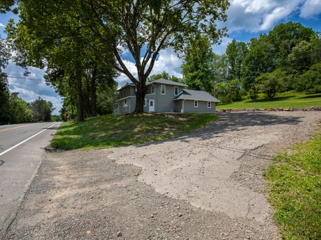 An image featuring plant, cloud, sky, building, tree, house, road surface, asphalt, land lot, grass at 17899 US-6.