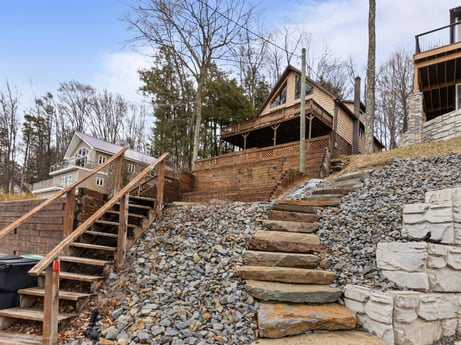 An image featuring sky, cloud, stairs, wood, tree, house, landscape, building, lumber, bedrock at 815 Lakeside Dr.
