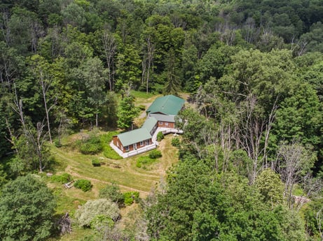 An image featuring plant, tree, natural landscape, building, highland, house, cottage, landscape, road, shrub at 154 Fox Run Rd.