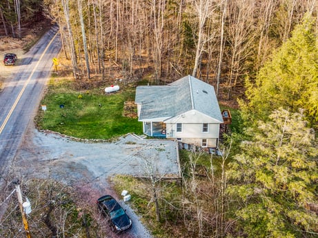 An image featuring plant, tree, wood, motor vehicle, slope, grass, asphalt, watercraft, tire, landscape at 1061 Muncy St.