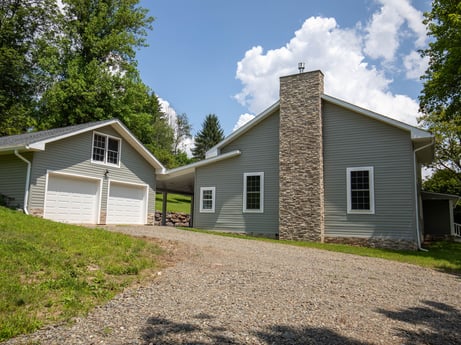 An image featuring plant, cloud, sky, building, window, tree, house, land lot, door, grass at 17899 US-6.