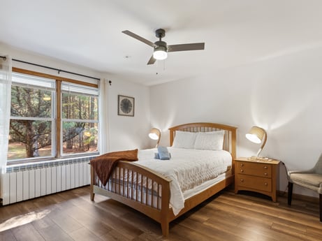 An image featuring furniture, window, ceiling fan, comfort, wood, lighting, fixture, floor, wood stain, flooring at 125 Rimstone Ct.