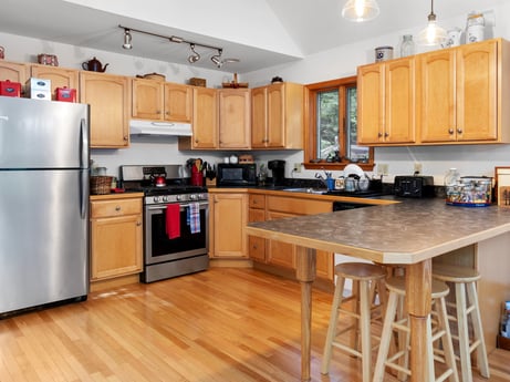 A kitchen at 459 Pine Hill Dr featuring: cabinetry, countertop, property, furniture, kitchen, kitchen appliance, wood, lighting, interior design, home appliance