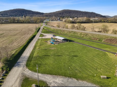 An image featuring plant, sky, slope, cloud, natural landscape, road surface, tree, land lot, asphalt, highland at River Access Rd.