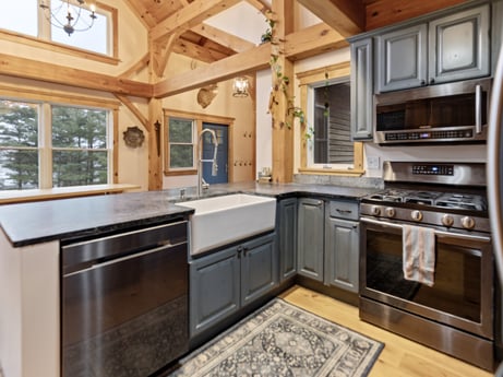A kitchen at 144 Milton Ln featuring: cabinetry, countertop, property, furniture, kitchen, kitchen appliance, kitchen stove, window, wood, interior design
