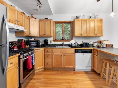 A kitchen at 459 Pine Hill Dr featuring: countertop, cabinetry, property, kitchen, kitchen appliance, wood, home appliance, lighting, drawer, kitchen sink