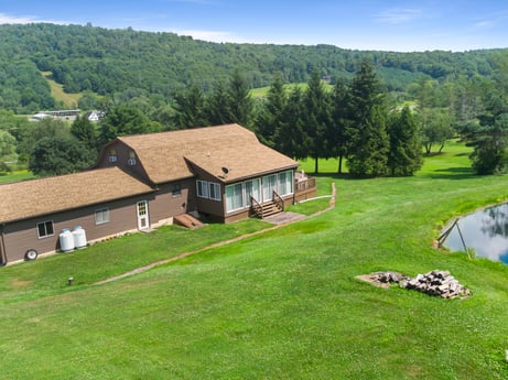 An image featuring sky, property, plant, building, ecoregion, natural landscape, tree, natural environment, land lot, house at 6583 N Rome Rd.