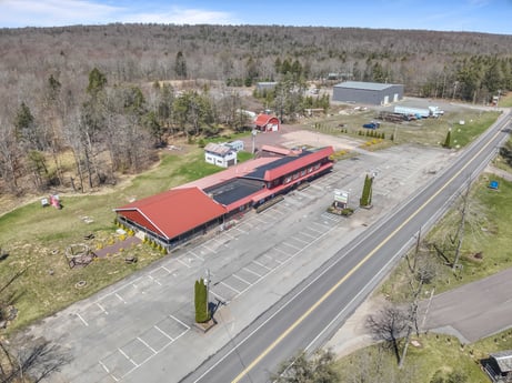 An image featuring sky, plant, asphalt, slope, land lot, road surface, urban design, cloud, building, landscape at 4741 US-220.