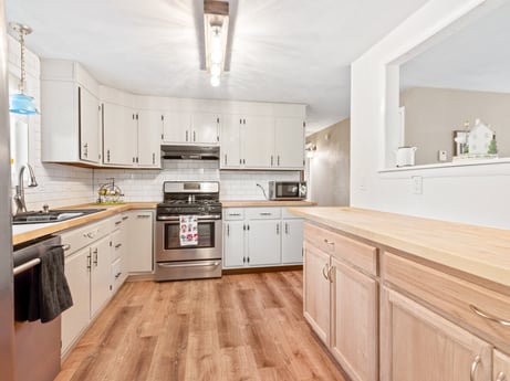 A kitchen at 491 Hillcrest Dr featuring: cabinetry, countertop, property, white, drawer, kitchen, sink, wood, kitchen stove, interior design