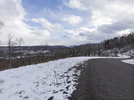 An image featuring cloud, sky, plant, snow, natural landscape, highland, mountain, tree, asphalt, road surface at Hemlock Hill Rd.