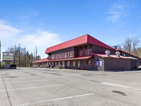 An image featuring sky, cloud, building, asphalt, tree, window, road surface, facade, automotive tire, city at 4741 US-220.