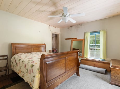 An image featuring furniture, property, building, ceiling fan, window, comfort, wood, lighting, cabinetry, interior design at 1039 Old Bernice Rd.