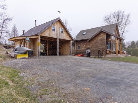 An image featuring sky, property, plant, building, tree, house, land lot, asphalt, road surface, window at 144 Milton Ln.
