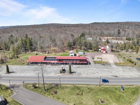 An image featuring sky, cloud, plant, asphalt, tree, vehicle, road surface, slope, land lot, motor vehicle at 4741 US-220.