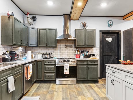 A kitchen at 17899 US-6 featuring: countertop, cabinetry, kitchen stove, kitchen, wood, drawer, flooring, interior design, floor, sink