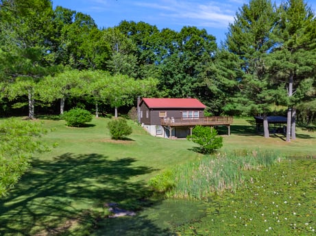 An image featuring plant, property, sky, natural landscape, cloud, tree, building, land lot, vegetation, house at 735 Midnight Ln.