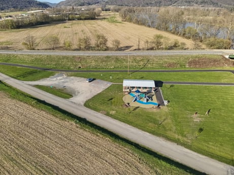 An image featuring plant, slope, land lot, natural landscape, asphalt, thoroughfare, grass, tree, grassland, plain at River Access Rd.