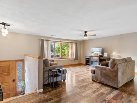 An image featuring couch, table, wood, interior design, flooring, floor, chair, hall, hardwood, living room at 491 Hillcrest Dr.