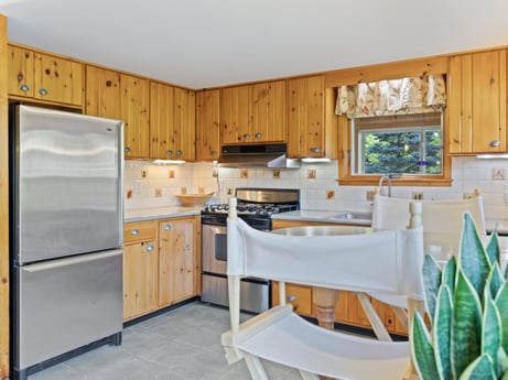A kitchen at 130 Haighs Pond Rd featuring: cabinetry, furniture, table, kitchen appliance, kitchen, countertop, building, plant, chair, wood