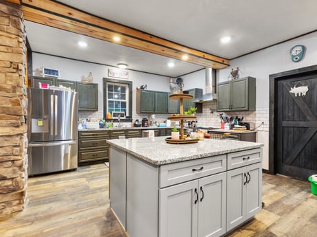 A kitchen at 17899 US-6 featuring: cabinetry, countertop, furniture, sink, tap, kitchen, wood, interior design, kitchen stove, kitchen appliance