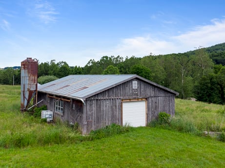 An image featuring sky, cloud, plant, building, wood, natural landscape, tree, land lot, house, grass at 709 Creek Rd.