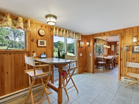 An image featuring furniture, table, plant, chair, wood, interior design, wood stain, picture frame, floor, door at 130 Haighs Pond Rd.