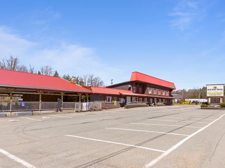 An image featuring sky, cloud, building, asphalt, road surface, commercial building, city, gas, road, facade at 4741 US-220.