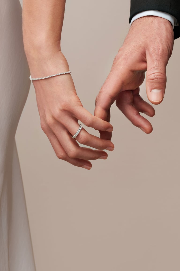 Zwei Hände berühren sich; an einer Hand ist ein Ring sichtbar.
