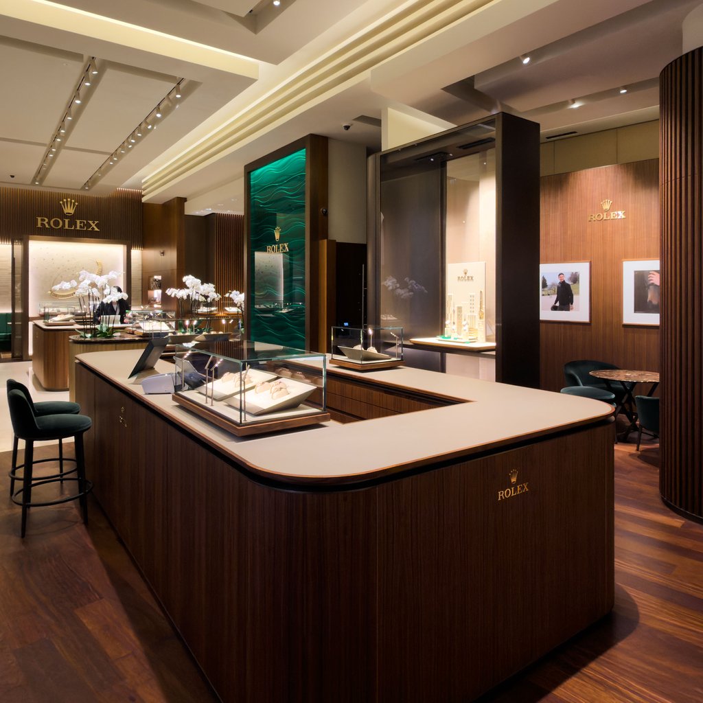 Innenansicht der Rolex Boutique by Wagner in der Tuchlauben 2 mit Holzvertäfelungen, Glasvitrinen und grüner Aqua-Wand.