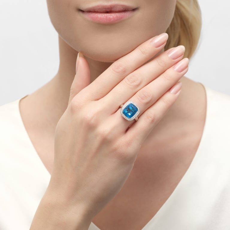 Jolie Cushion Ring aus 18 Kt Weißgold mit Diamanten und Topas, an einer Hand getragen