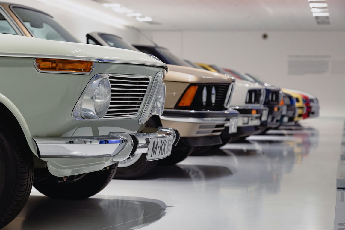 A row of classic cars lined up on display in a bright showroom