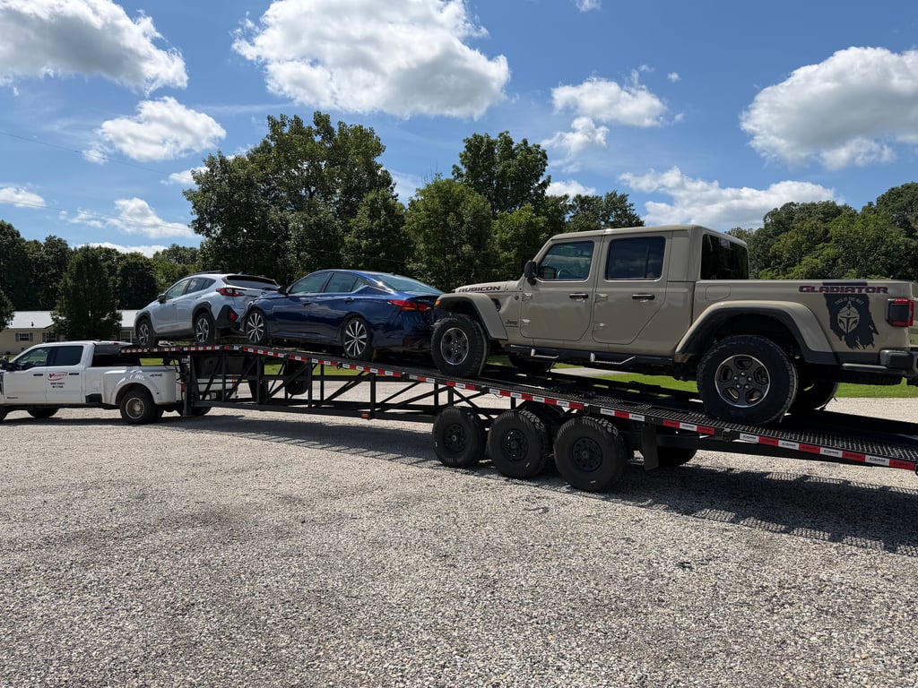 Velocity Logistics truck and Stryker wedge carrier loaded with a Jeep Gladiator Rubicon and two cars