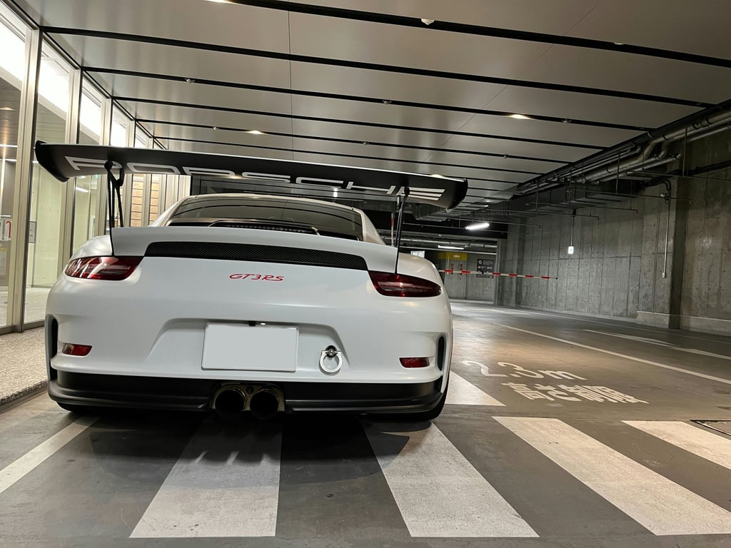 A low sports car being unloaded from a trailer at dusk