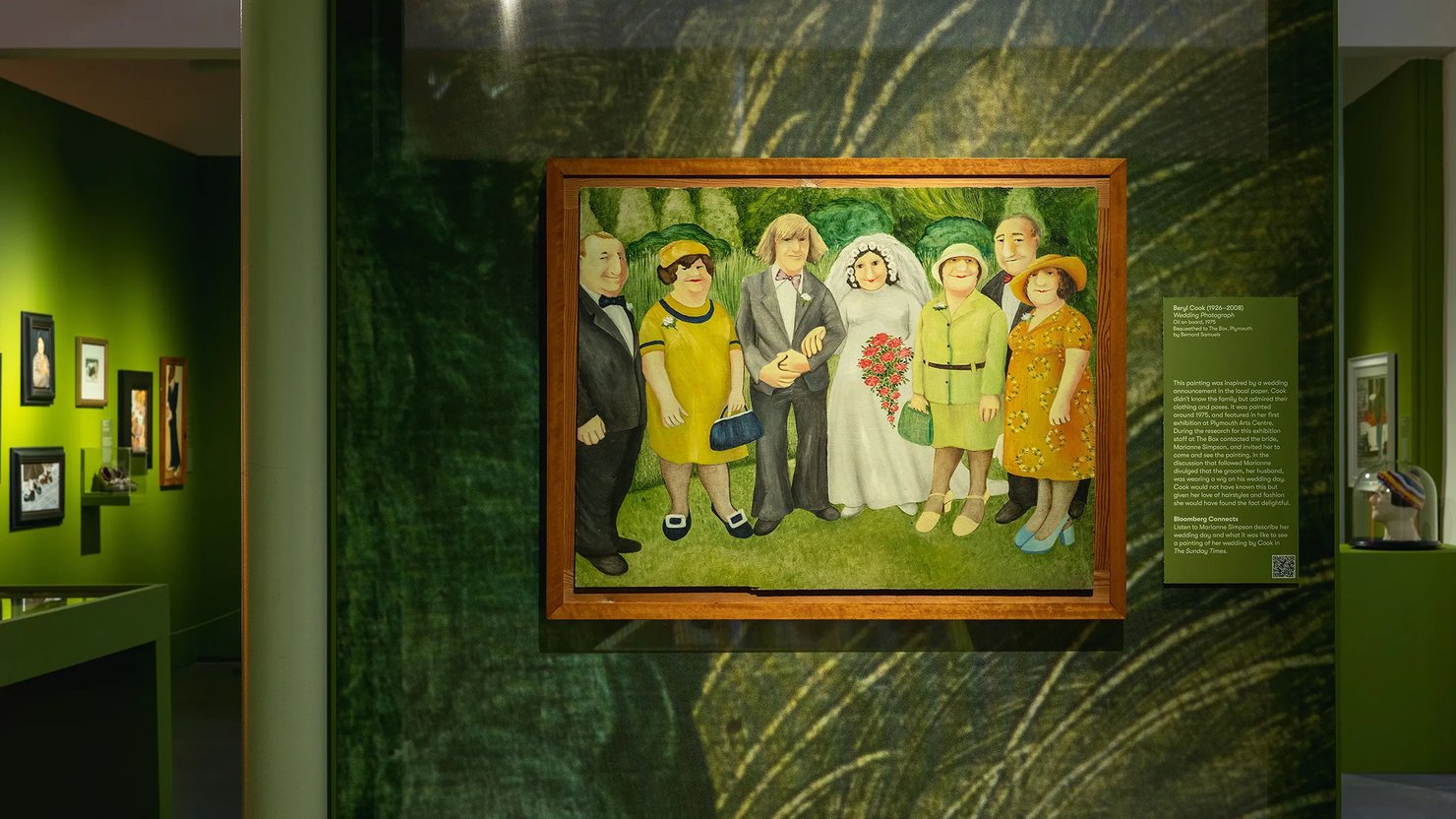 Photograph showing a painting of a wedding scene in an exhibition space that is green