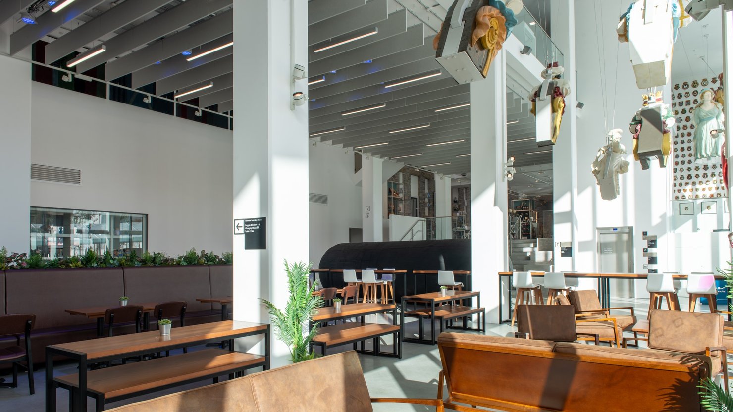 Photograph showing a large dining area with floating figureheads above it