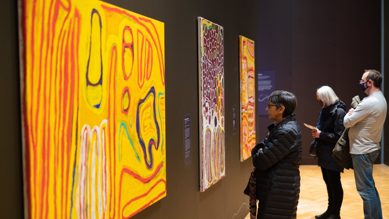 People looking at paintings in an exhibition