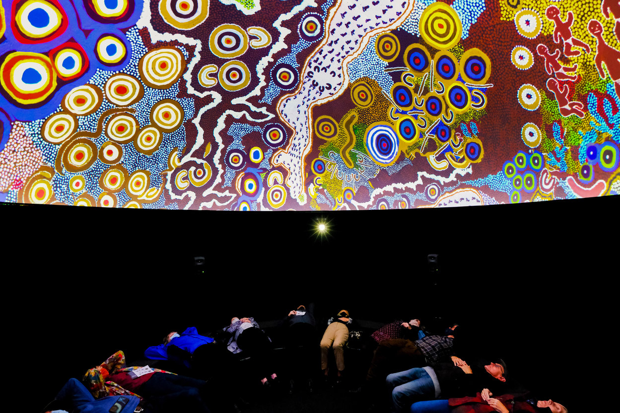 Visitors lying down watching immersive footage in a dome